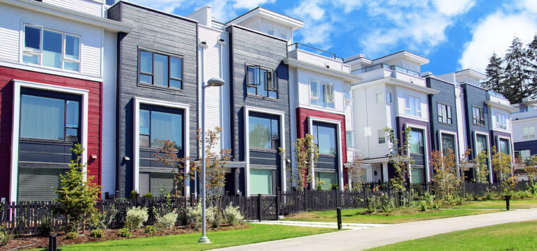 Beautiful new construction attached townhomes with colorful summer gardens. Example of new home builder communities.