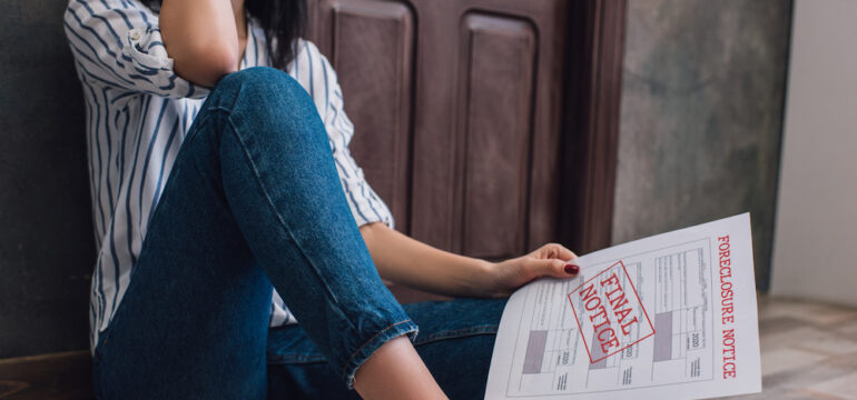 Cropped view of woman holding document with foreclosure and final notice from a zombie mortgage.