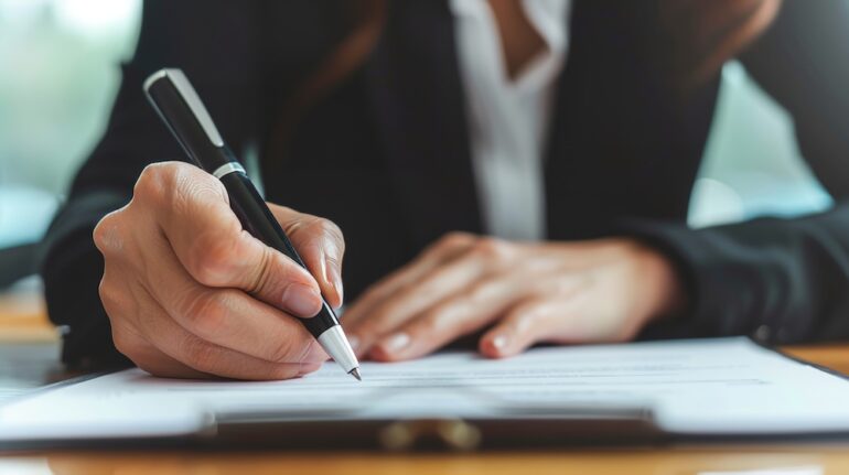 Man filling out document to request written verification of employment.