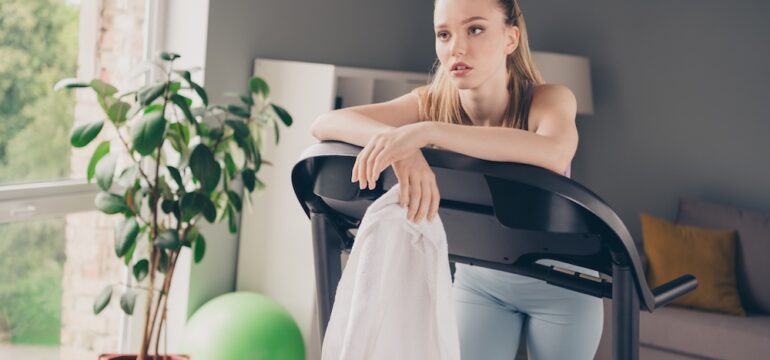 Photo of girl training at home on gym equipment she has buyers remorse after buying.